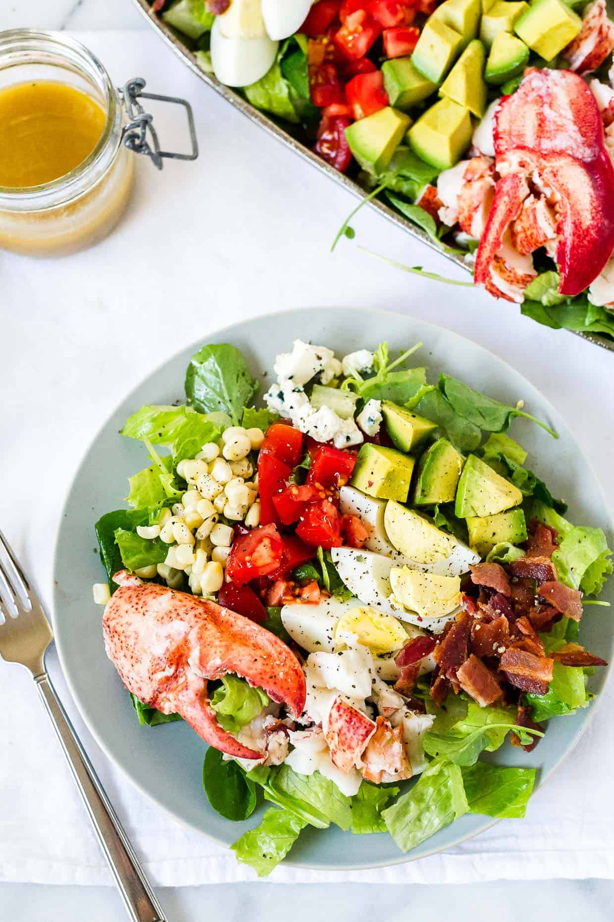 Serving of Lobster Cobb Salad on blue plate.