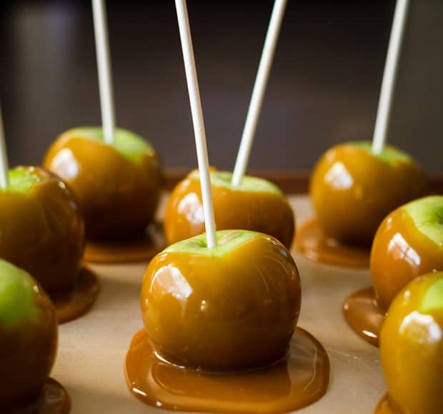 Caramel Apples cooling on a baking sheet.