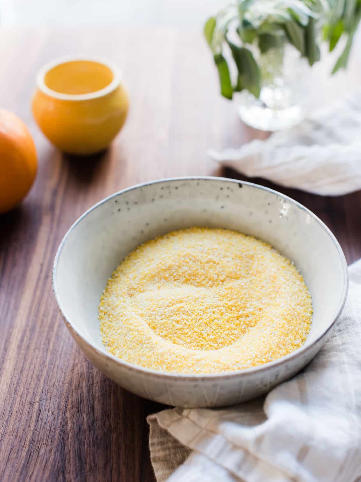 Bowl filled with ready-to-cook polenta on a wooden counter top. 