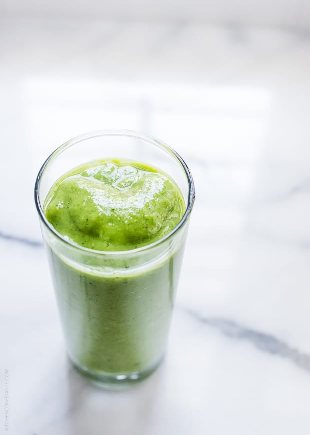 Mango Spinach Green Smoothie in a glass on a marble surface