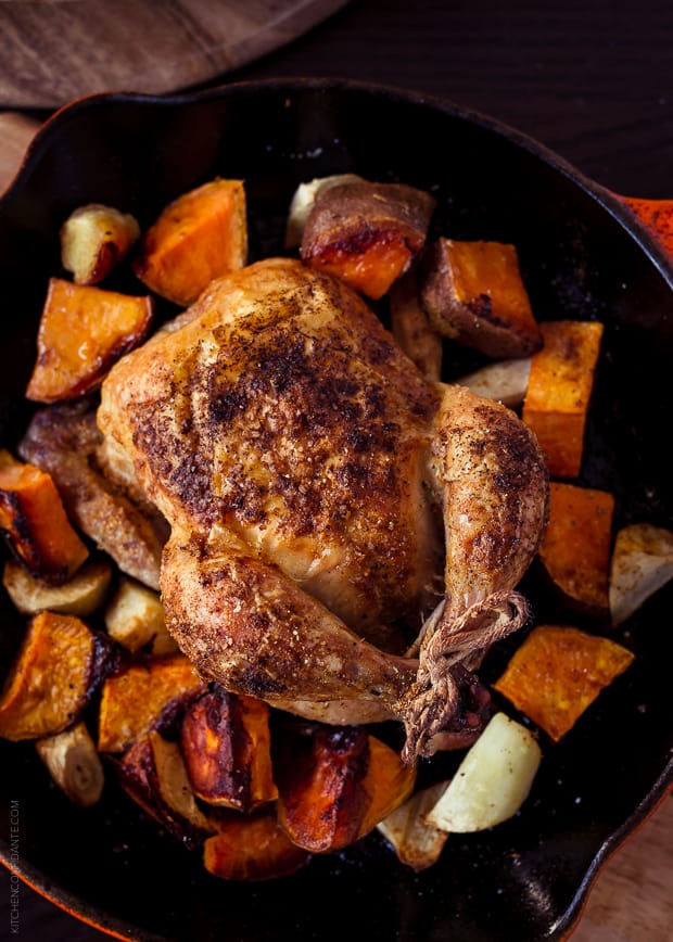 Roasted Cornish Hens and chopped sweet potatoes in a cast iron skillet.