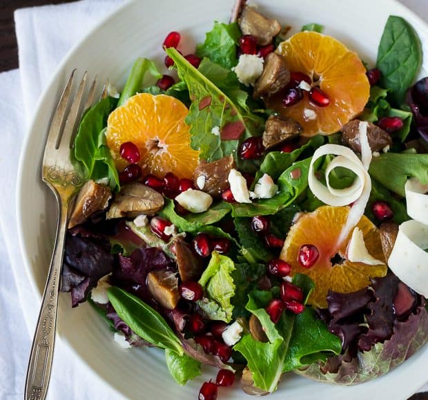 A green salad with citrus slices, gorgonzola, pomegranate arils, roasted chestnuts, and a pomegranate dressing.