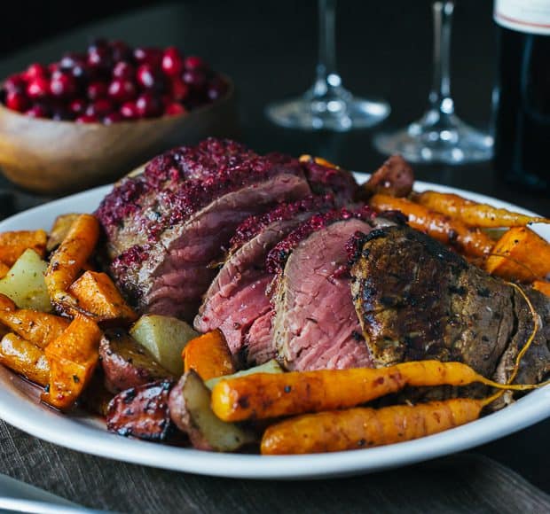 Cranberry Balsamic Crusted Chateaubriand sliced on a serving platter.