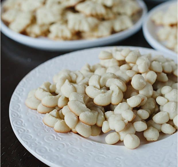 Lemon Spritz Cookies arranged on white serving platters.