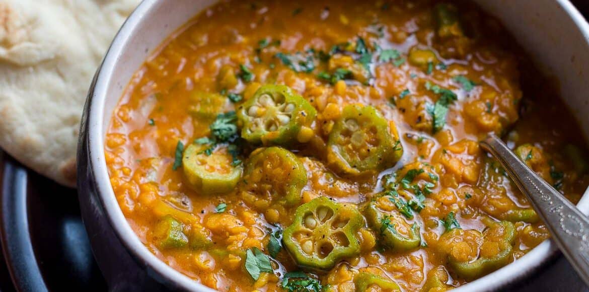 A rustic bowl filled with Lentil Okra Curry.