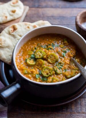 A rustic bowl filled with Lentil Okra Curry.