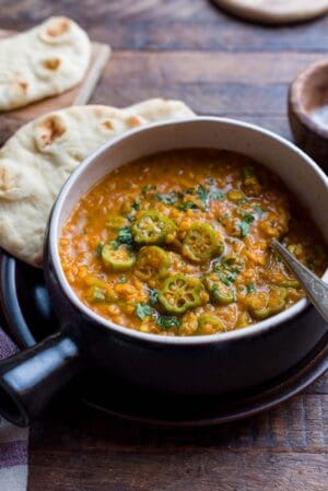 A rustic bowl filled with Lentil Okra Curry.