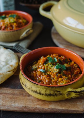 A rustic bowl filled with Lentil Okra Curry.