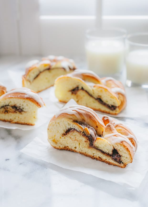 Slices of Braided Nutella Bread with glasses of milk nearby.