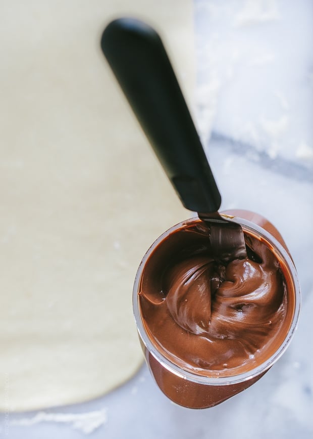 A jar of Nutella with a spatula inside.