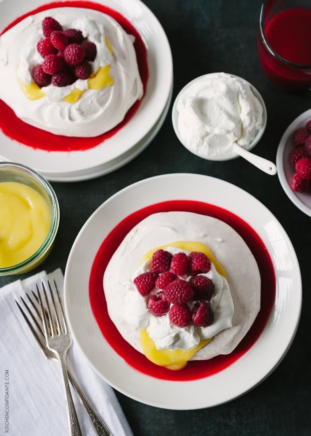 Meyer Lemon and Raspberry Pavlova topped with fresh whipped cream and raspberries.