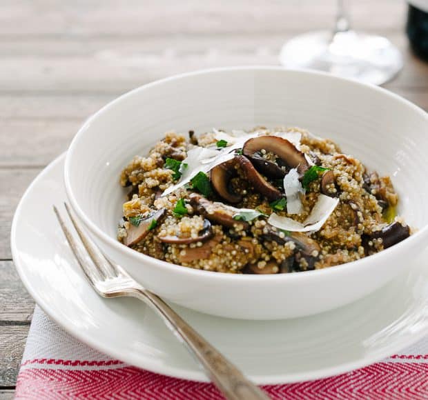 A white bowl on a table filled with Mushroom Quinoa Risotto.