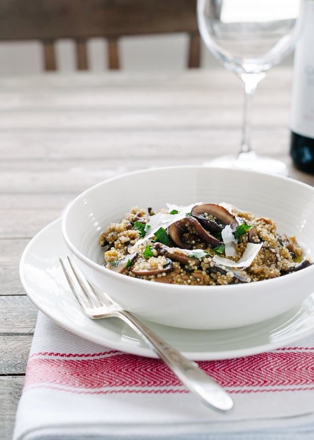 A white bowl on a table filled with Mushroom Quinoa Risotto.