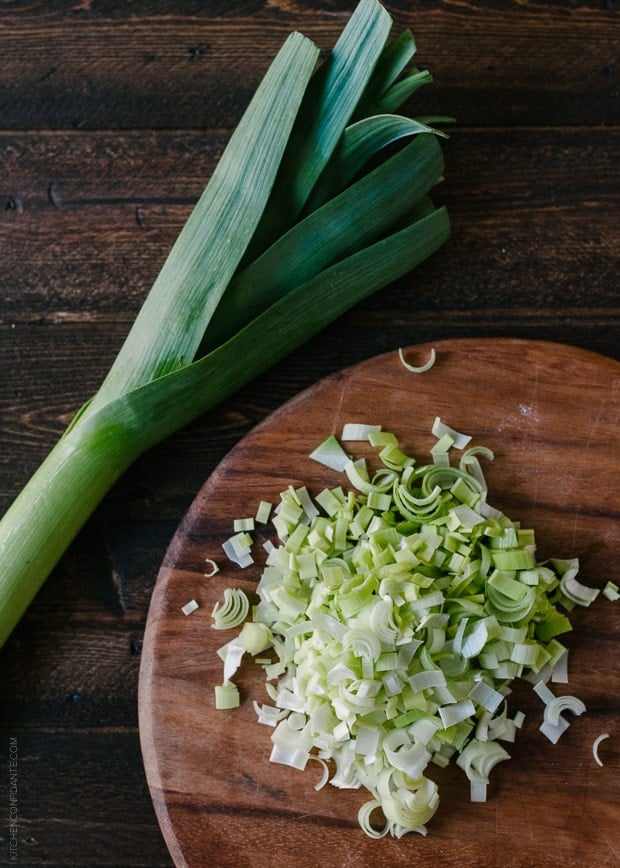 Chopped leeks on a wooden cutting board.