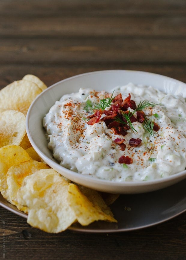 A white bowl filled with creamy dip and topped with chopped bacon. 