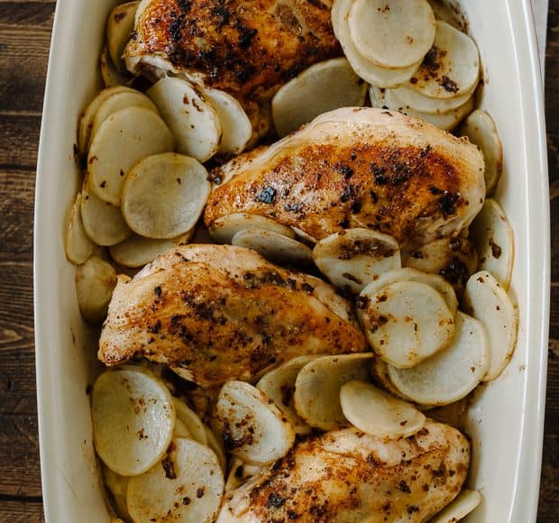 A large baking dish filled with Roast Chicken with Thai-Chili Compound Butter and sliced potatoes.