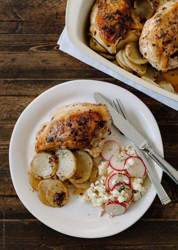 Roast Chicken with Thai-Chili Compound Butter served on a plate with sliced and roasted potatoes.