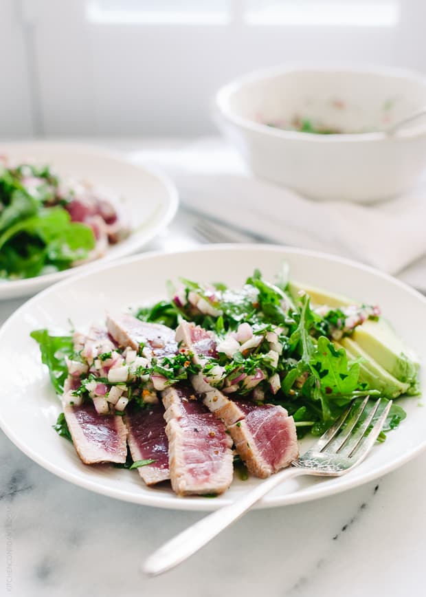 Seared Ahi Tuna over a salad on a white plate.