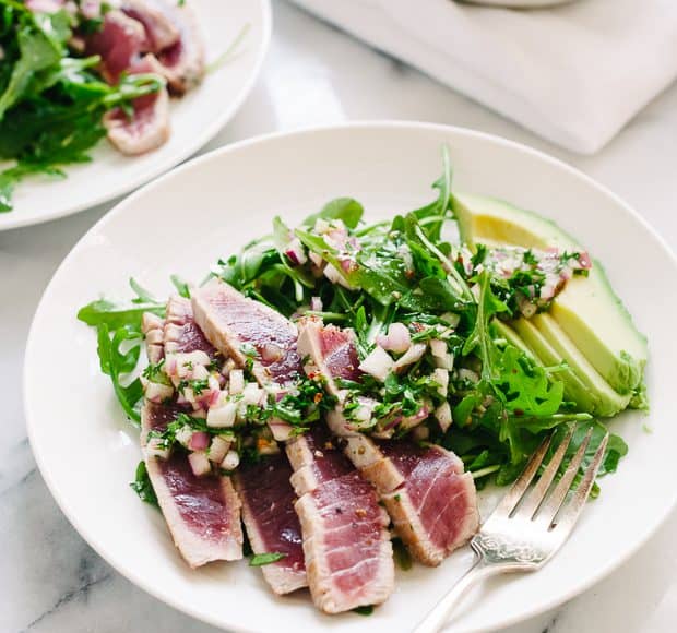 Seared Ahi Tuna with Chimichurri Sauce on a white plate.