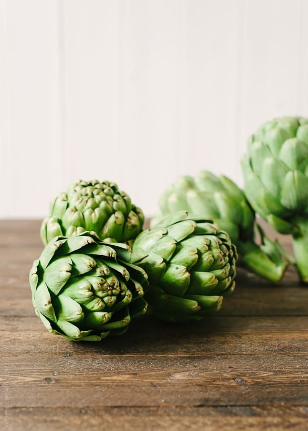 Artichokes on a wooden surface.