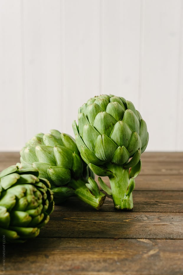 Artichokes on a wooden surface.