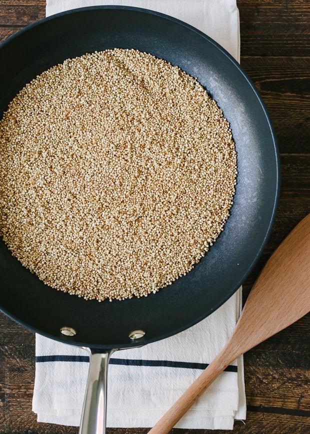 Quinoa toasting in a pan.