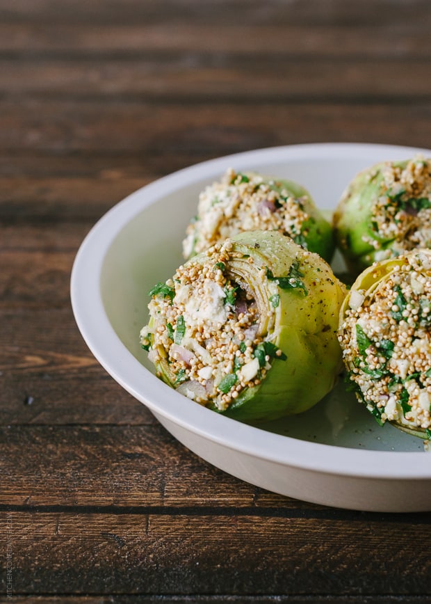 Toasted Quinoa Stuffed Artichokes in a bowl, ready to bake.
