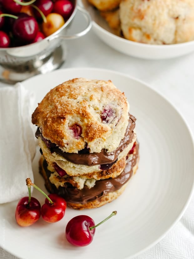 Cherry Nutella Scones on a white plate with fresh cherries.