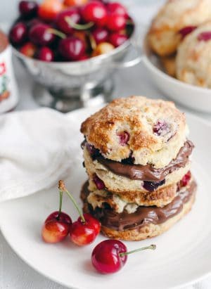 Cherry Nutella Scones split and filled with Nutella on a white plate.