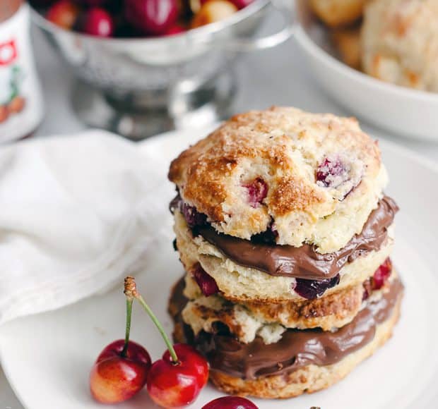 Cherry Nutella Scones split and filled with Nutella on a white plate.