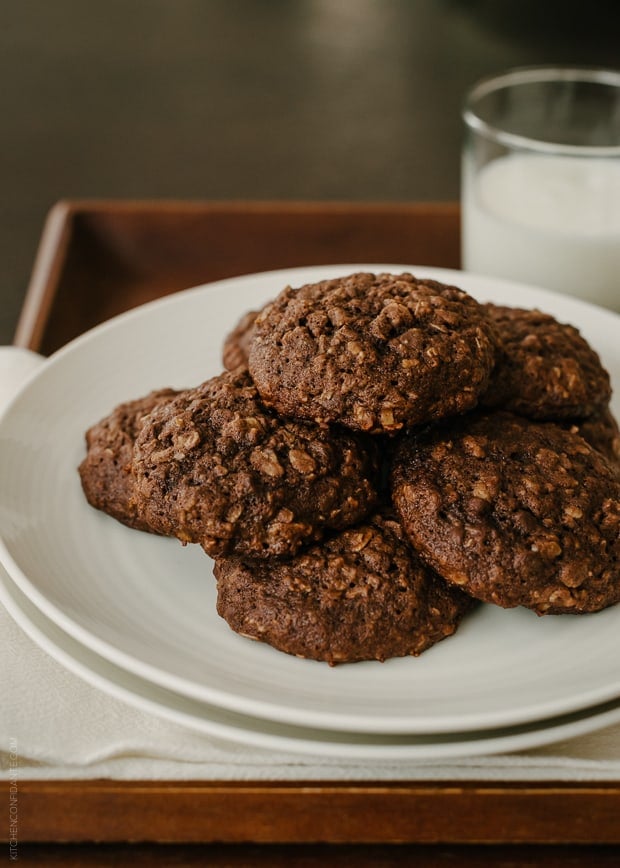 A glass of milk and a plate of cookies on a tray.