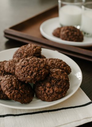 A white plate filled with chocolate oatmeal cookies.