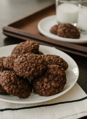 A white plate filled with chocolate oatmeal cookies.