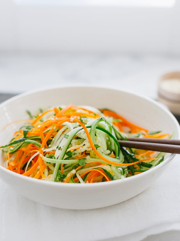 Julienned carrots and cucumbers tossed with dressing for an Asian Cucumber Salad.