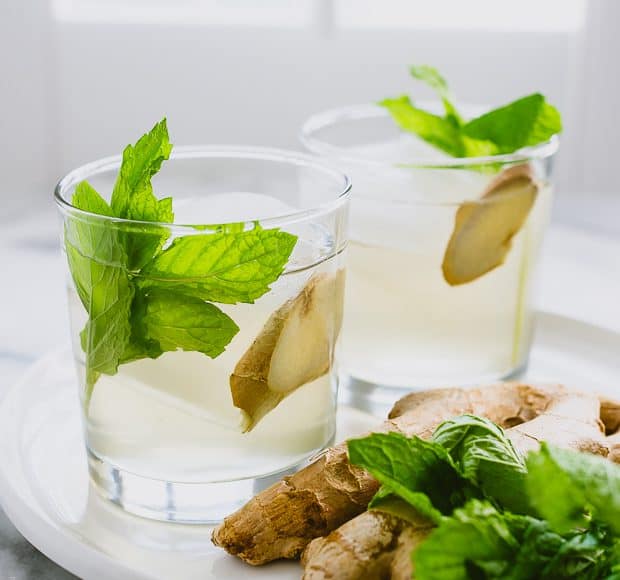 Two coconut water coolers garnished with mint and ginger.