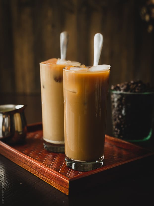 Homemade Thai Iced Coffee stirred with condensed milk in tall glasses.