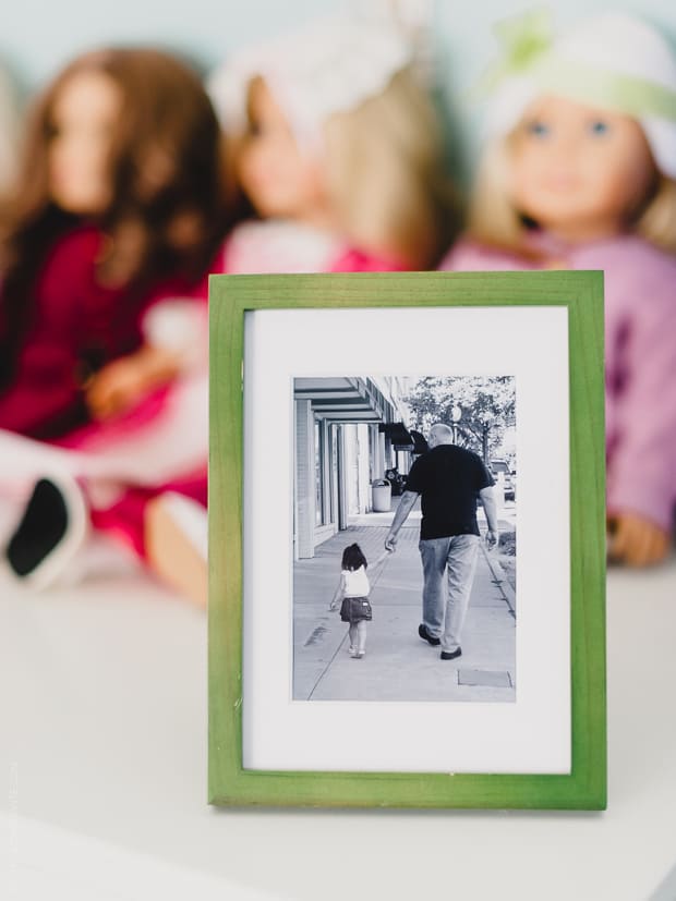 A framed photo of a young girl and her grandfather holding hands as they walk down a sidewalk.