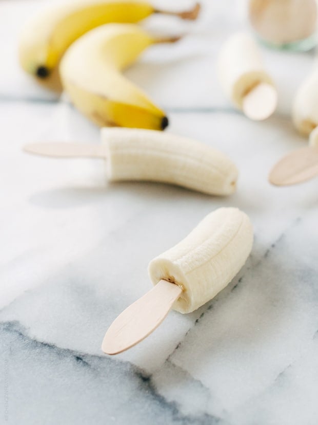 Halved bananas with popsicle sticks inserted.