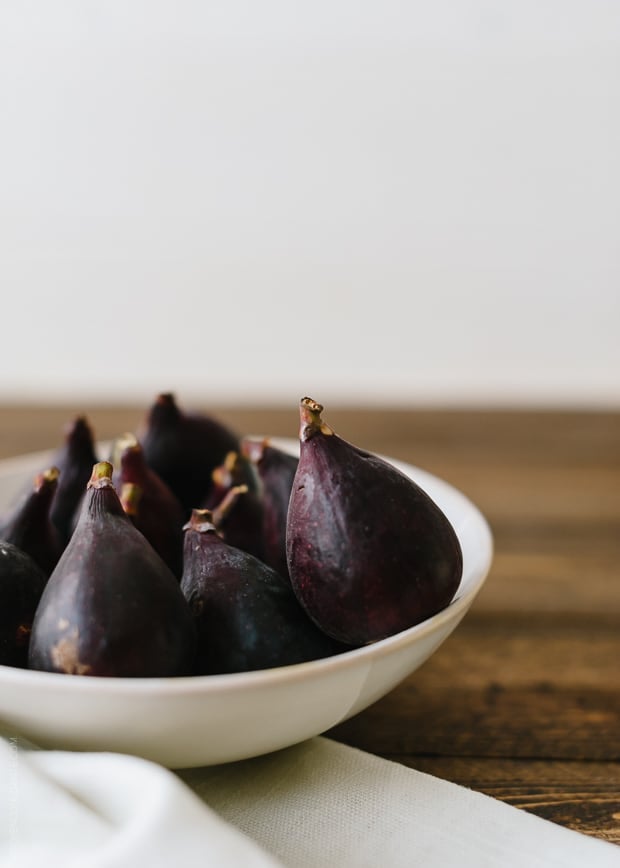 A white bowl of fresh figs.