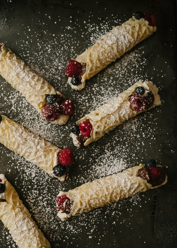 Rolled Waffle Cookies (Pizzelle) sprinkled with powdered sugar.