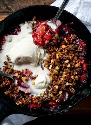 Stovetop Rhubarb-Cherry Crisp in a skillet topped with ice cream.