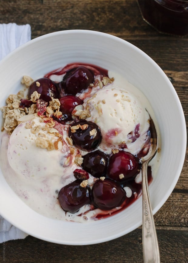 Fresh Cherry Wine Sauce with Ice Cream in a white bowl on a wooden background.