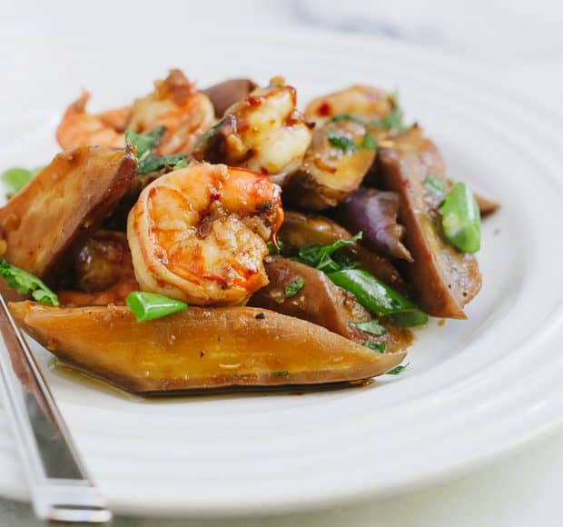 An eggplant and shrimp stir fry served on a white plate.