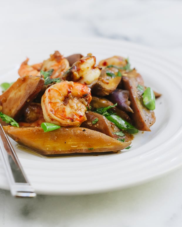 An eggplant and shrimp stir fry served on a white plate.