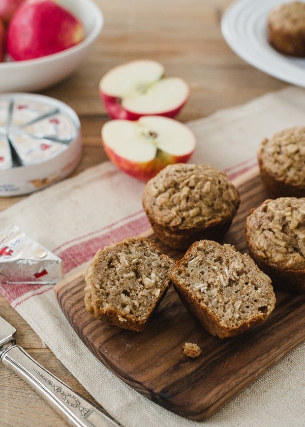 Apple Oat Muffins sliced on a wooden cutting board.