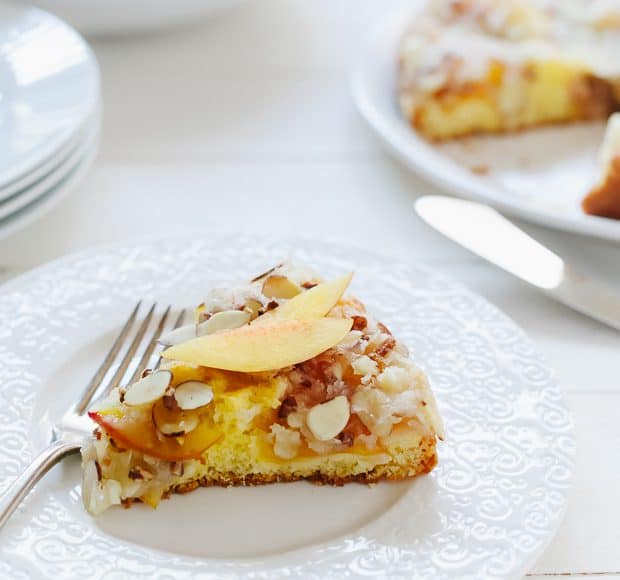 A slice of Nectarine Crumb Cake on a white plate.