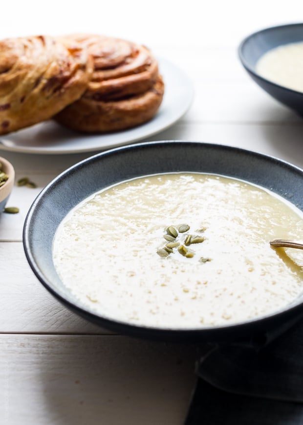 A bowl of creamy Parsnip Apple Soup topped with pumpkin seeds.