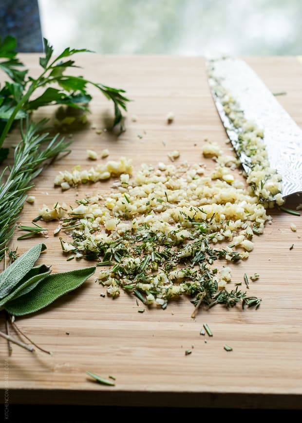 Chopped herbs on a wooden surface.