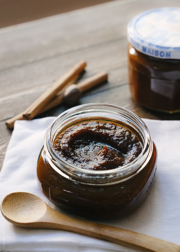 An open jar of pumpkin butter with a wooden spoon nearby.