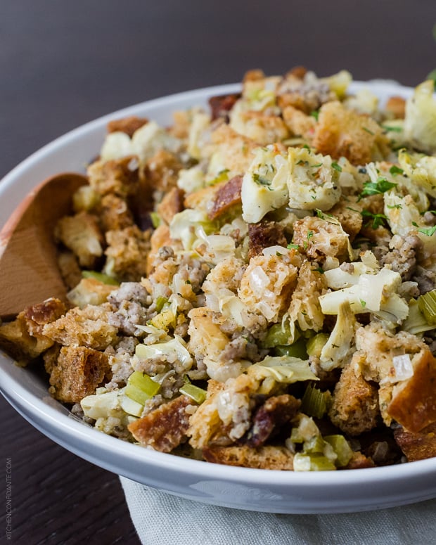 A large white serving platter filled with Artichoke Sourdough Stuffing with Jones Sausage.